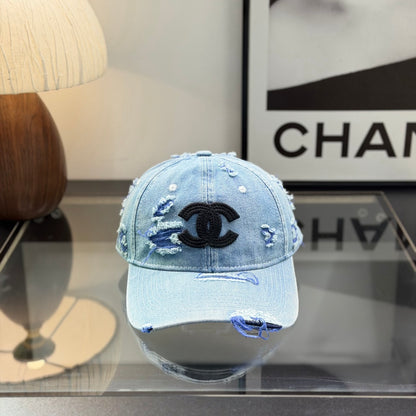 Distressed light wash denim baseball cap with frayed edges and embroidered front emblem.