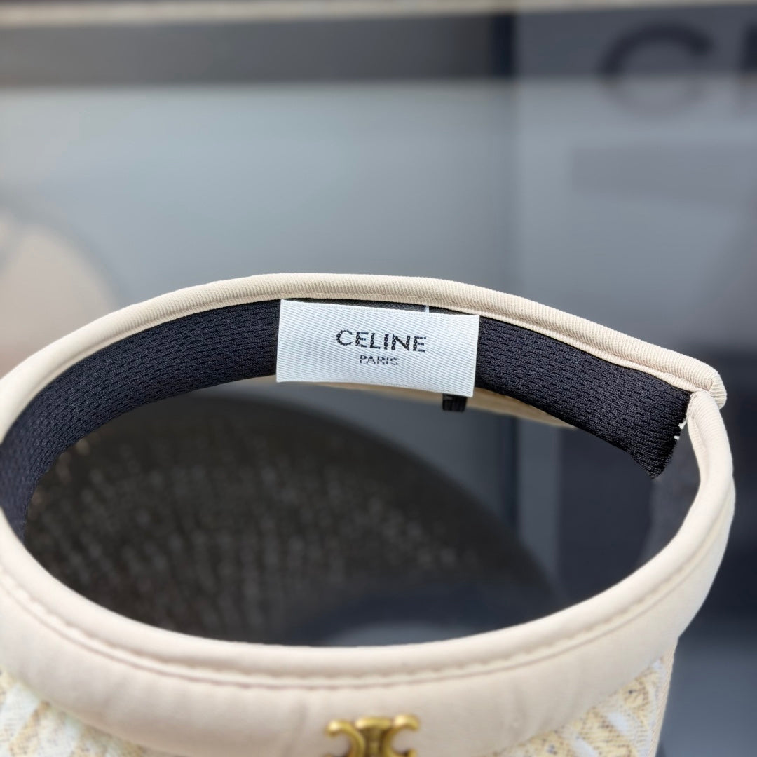 A beige straw sun visor with white polka dot mesh overlay and a gold metallic logo detail.