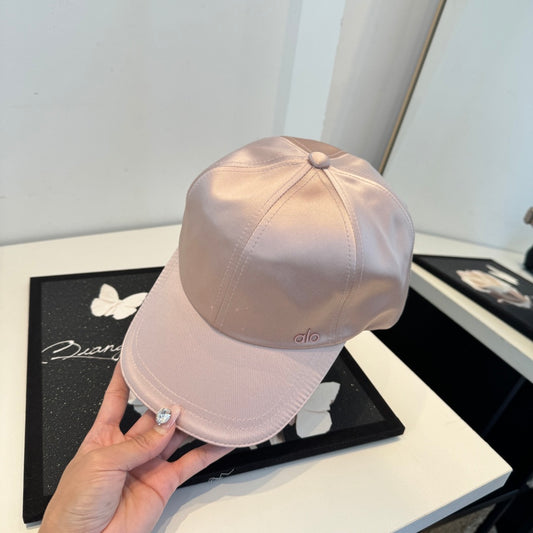 Dusty pink satin baseball cap with a curved brim, featuring a minimalist adjustable back strap.