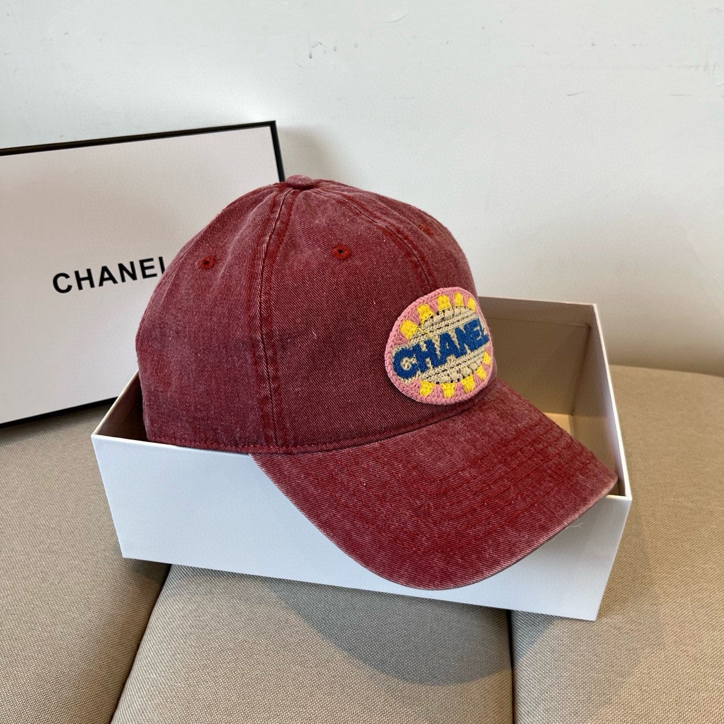 Red distressed cotton baseball cap featuring a colorful embroidered circular graphic patch.