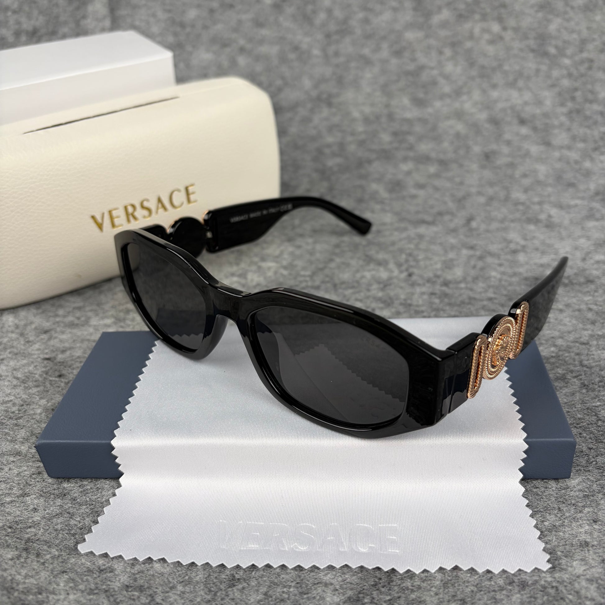 Classic black rectangular frame sunglasses featuring decorative gold-tone metallic side accents.