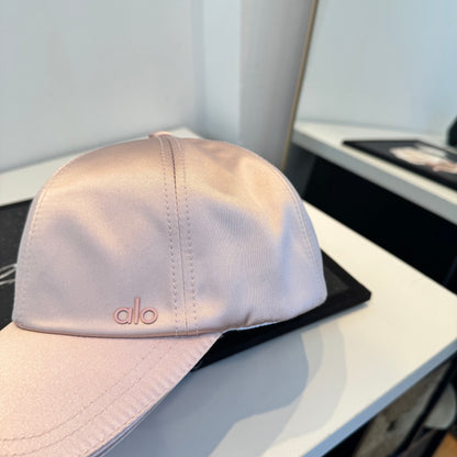 Dusty pink satin baseball cap with a curved brim, featuring a minimalist adjustable back strap.