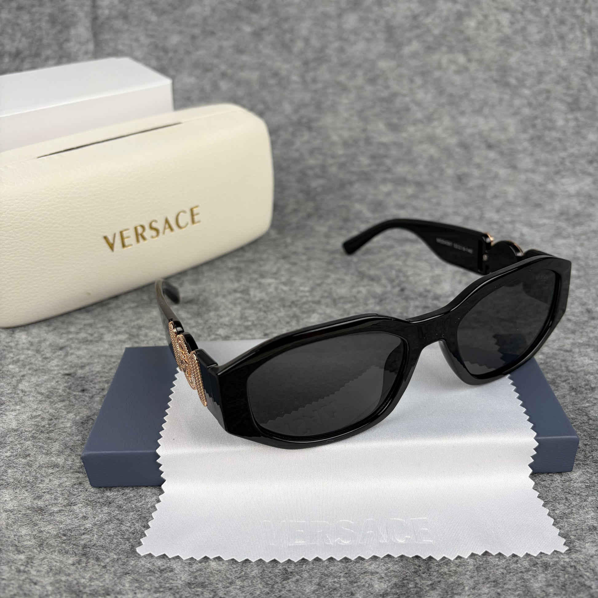 Classic black rectangular frame sunglasses featuring decorative gold-tone metallic side accents.