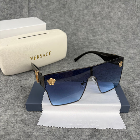 Oversized shield sunglasses with gradient blue lenses and gold metallic accents on the side arms.