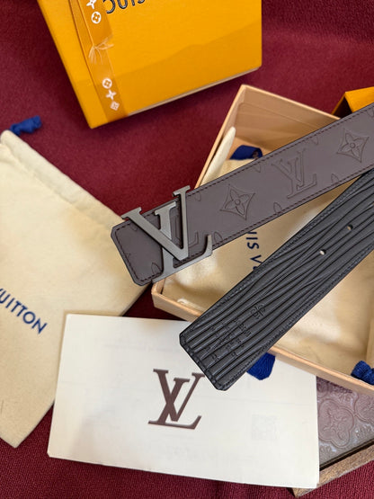 Close-up of a brown embossed leather belt featuring a matte metal buckle and patterned surface.