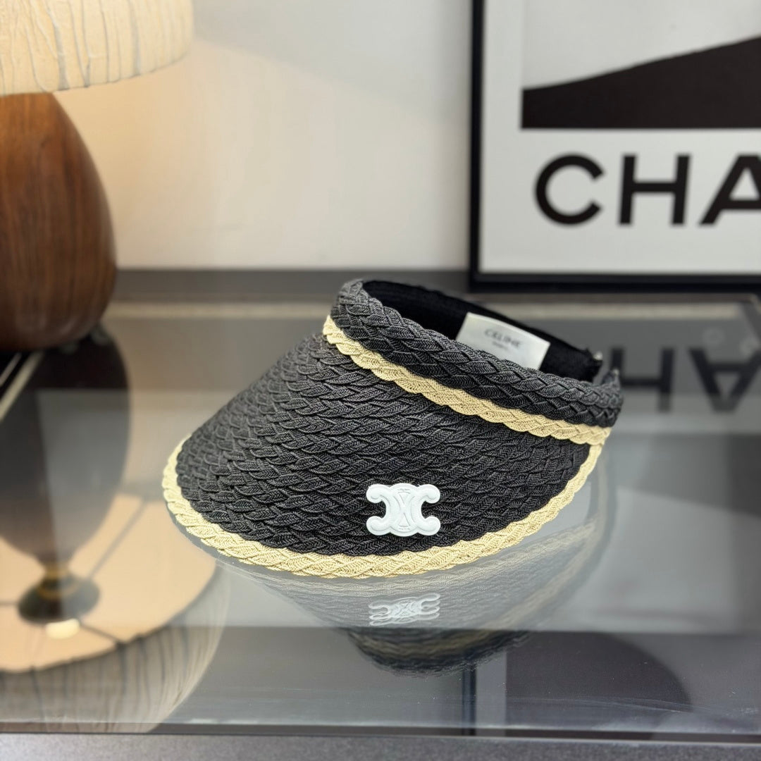 Close-up of a stylish woven straw sun visor with contrast border and white emblem detail.