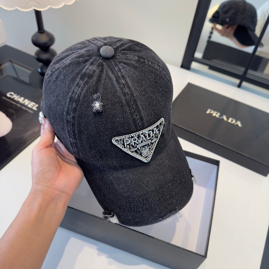A black distressed denim baseball cap with a sparkling triangular patch on the front center.