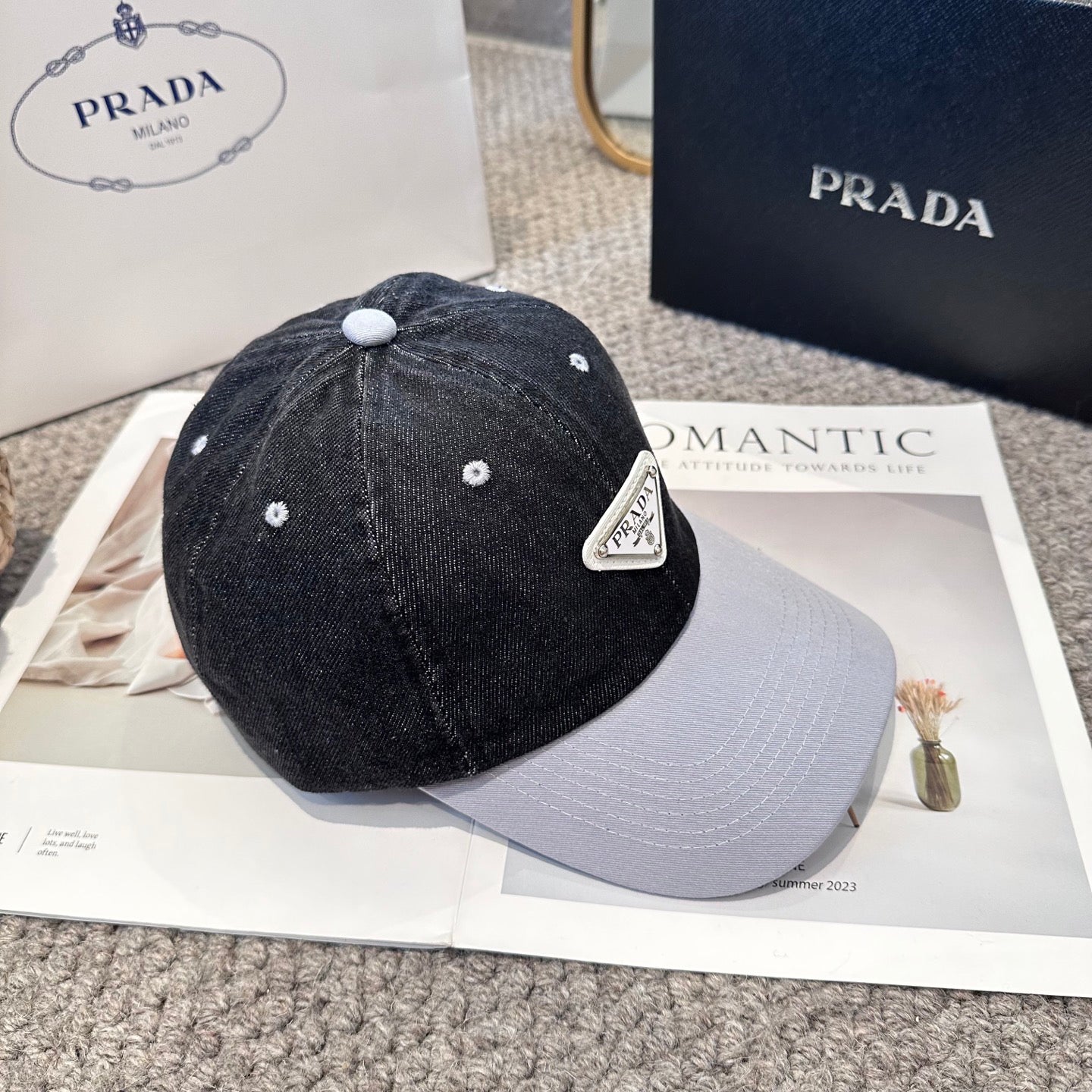 A two-tone denim baseball cap featuring a white triangle emblem patch on the front, neutral brim.
