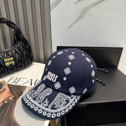 Navy blue baseball cap with white embroidered paisley patterns and an adjustable back strap.