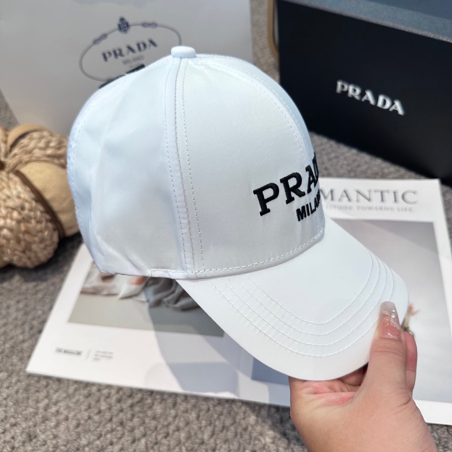 A clean white baseball cap featuring black embroidered lettering, structured crown, and curved visor