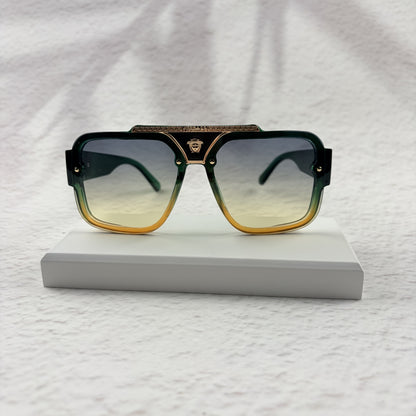 Oversized geometric sunglasses with green-to-yellow gradient lenses and gold metallic frame details.