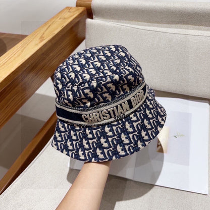 Close-up of a blue and beige monogram patterned cotton bucket hat with a wide brim and fabric band.