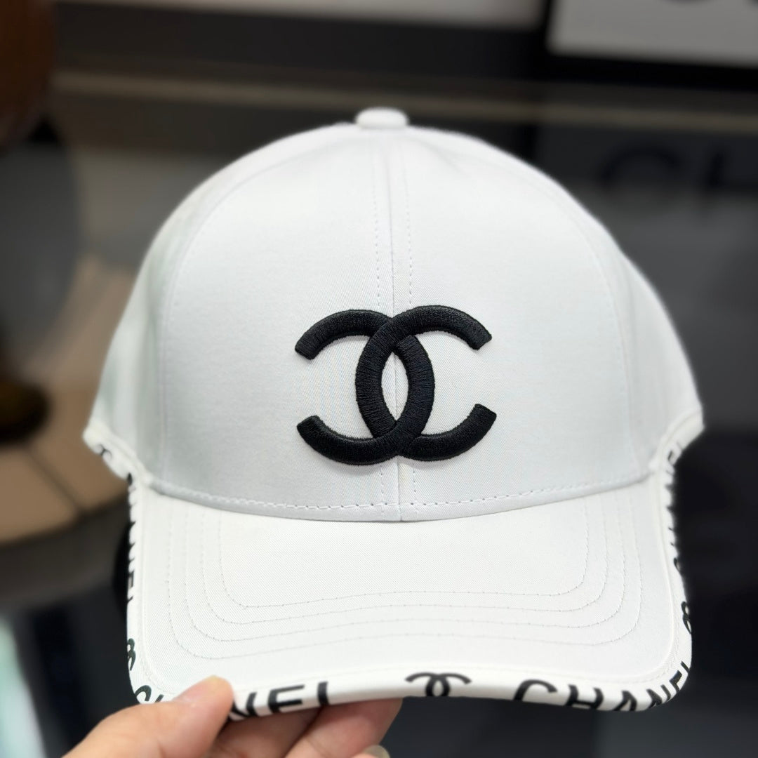 A white premium baseball cap with black embroidered logo details on a clean display surface.