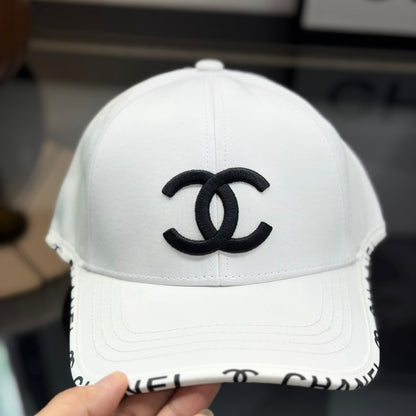 A white premium baseball cap with black embroidered logo details on a clean display surface.