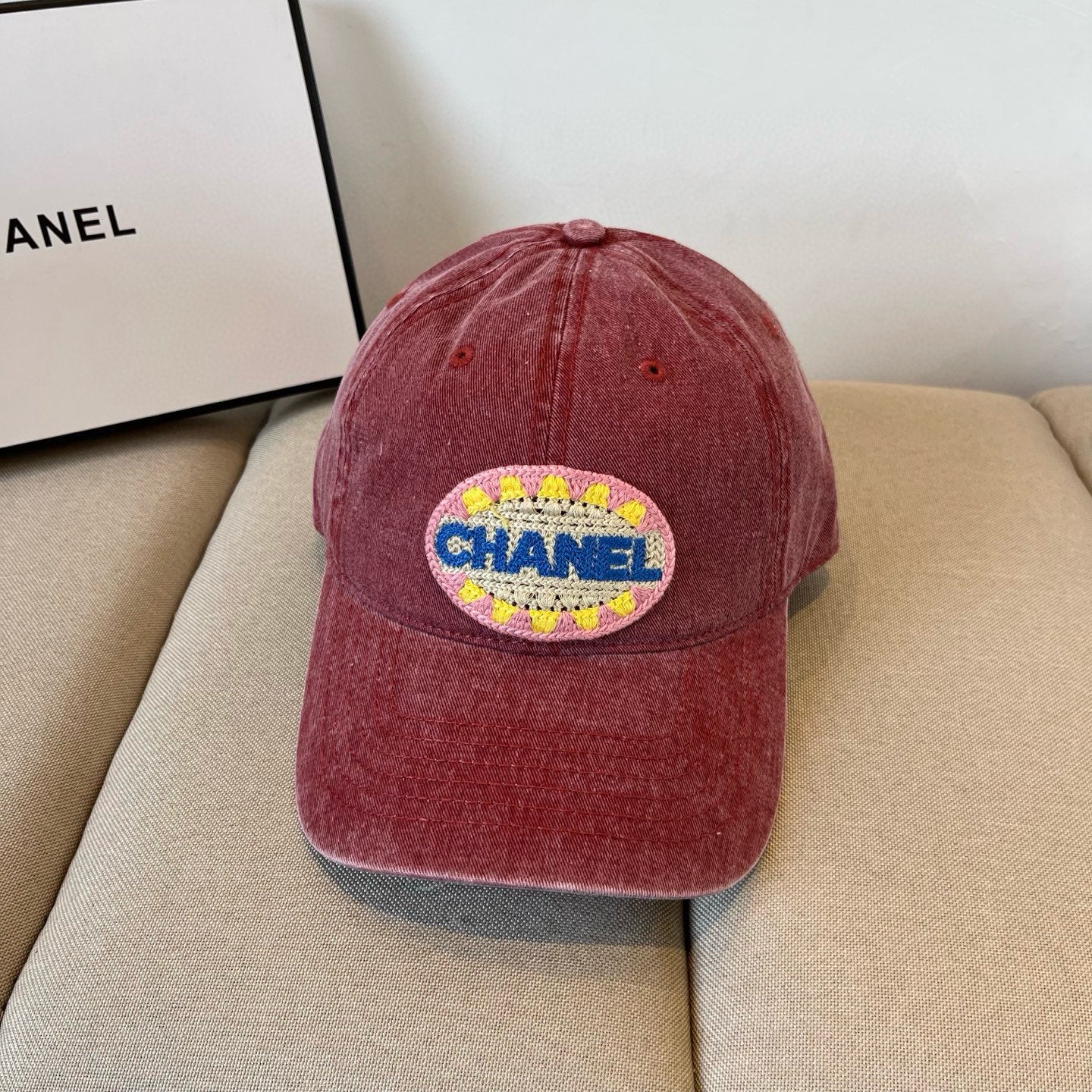 Red distressed cotton baseball cap featuring a colorful embroidered circular graphic patch.