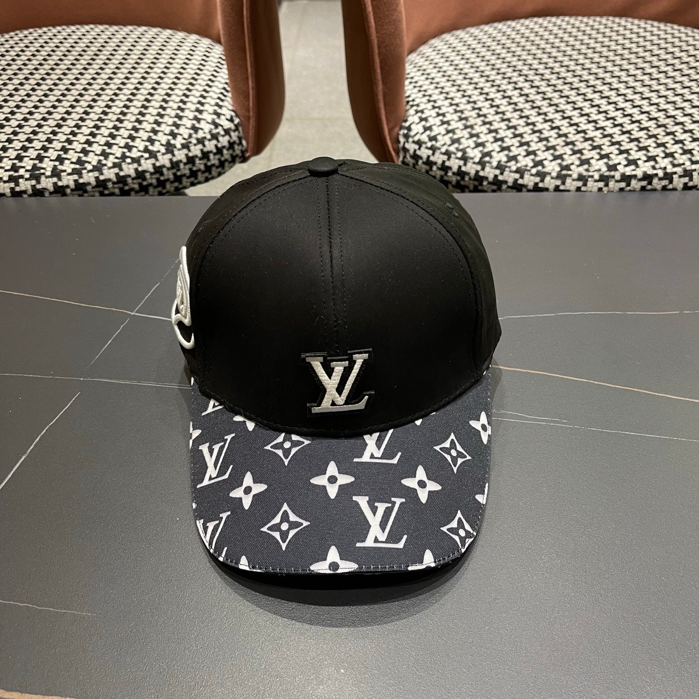 Black baseball cap featuring a raised minimalist logo and a striking geometric patterned brim.