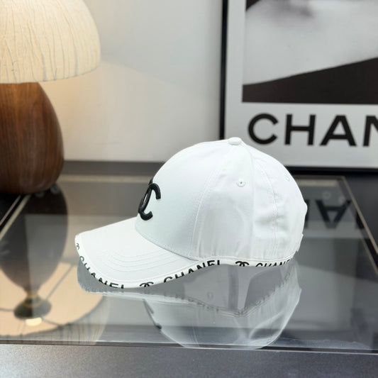 A white premium baseball cap with black embroidered logo details on a clean display surface.