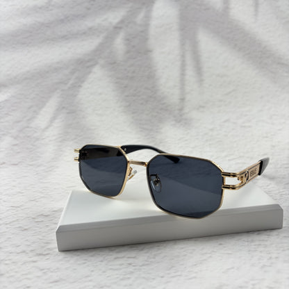Gold tone metal frame geometric sunglasses with dark lenses on a white display block.