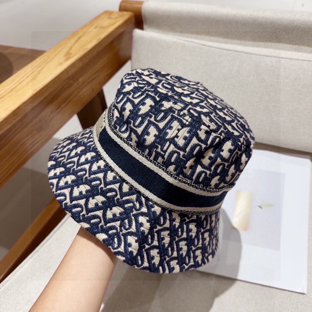 Close-up of a blue and beige monogram patterned cotton bucket hat with a wide brim and fabric band.