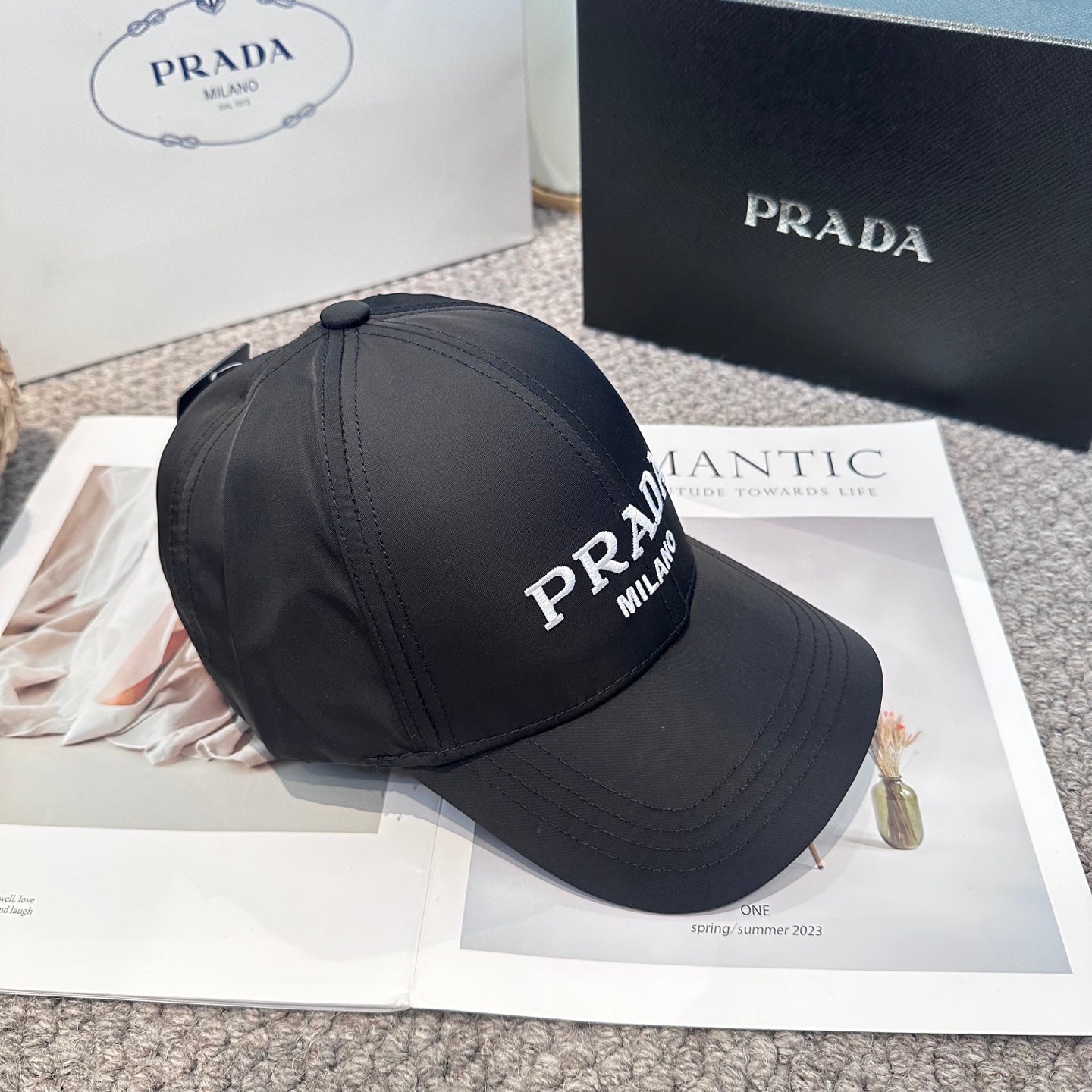 Black nylon baseball cap with white embroidered lettering and side metal logo plaque.