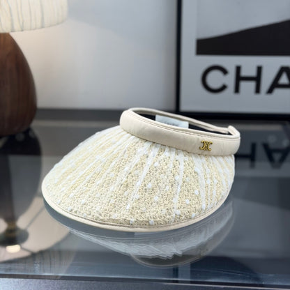 A beige straw sun visor with white polka dot mesh overlay and a gold metallic logo detail.
