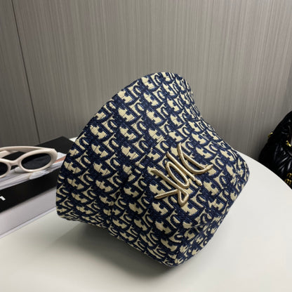 Close-up of a premium navy and beige monogram patterned bucket hat with central gold embroidery.
