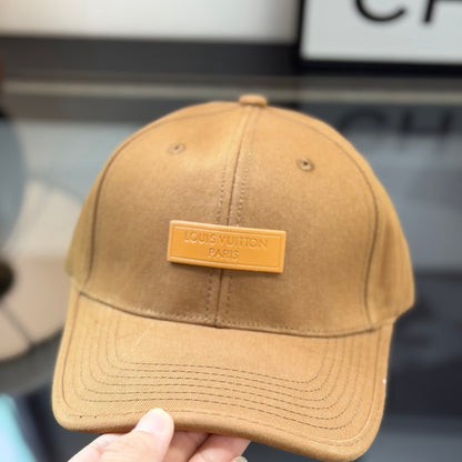 A premium camel-colored cotton baseball cap with a structured crown and an embossed leather patch.