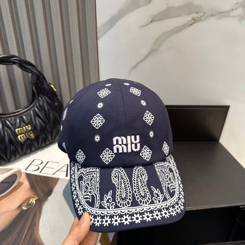 Navy blue baseball cap with white embroidered paisley patterns and an adjustable back strap.