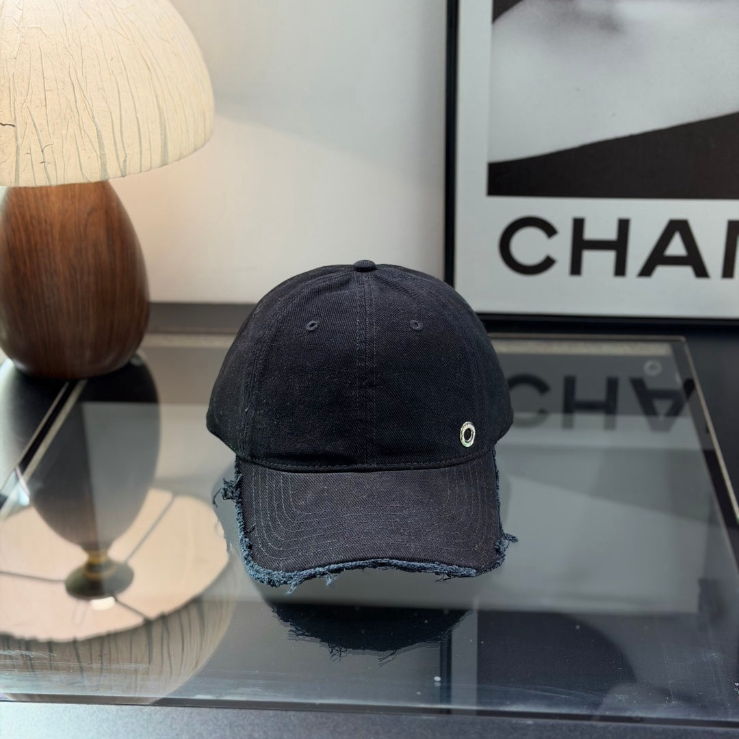 A black cotton baseball cap with a distressed brim and a small metallic circular side detail.