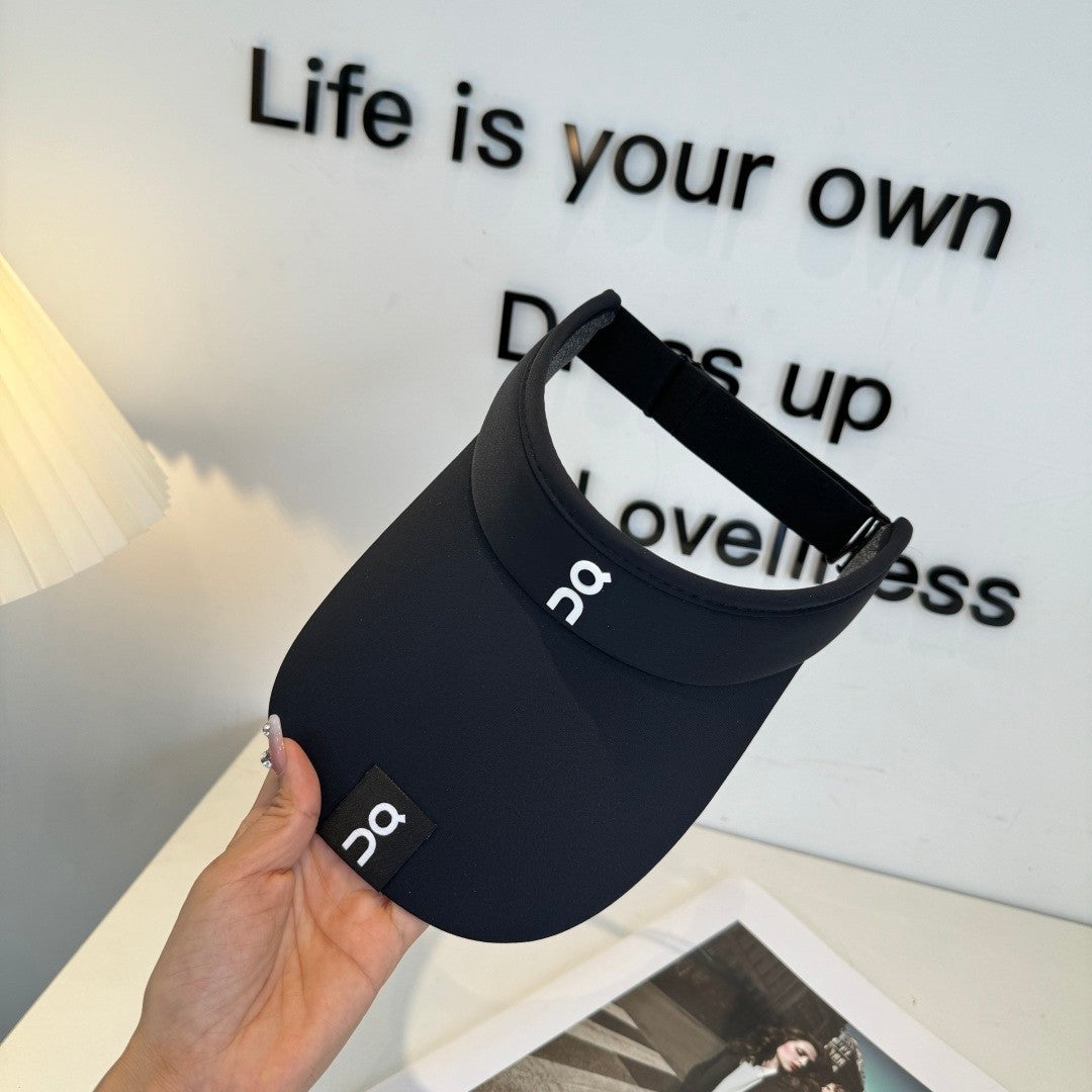 Close up of a black athletic sun visor with an adjustable strap, lightweight and breathable fabric.