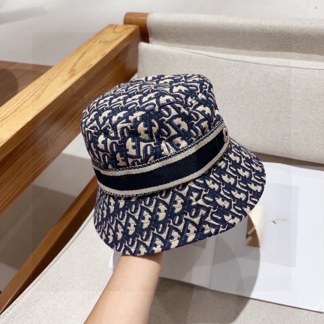 Close-up of a blue and beige monogram patterned cotton bucket hat with a wide brim and fabric band.