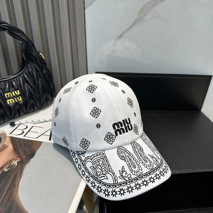 White cotton baseball cap with black paisley patterns and an adjustable drawstring back closure.