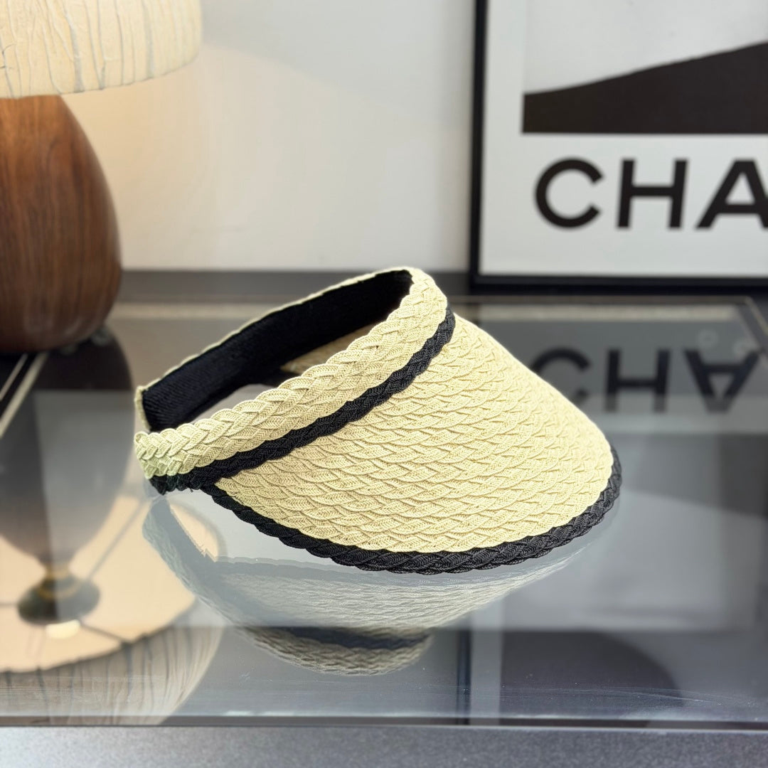 Woven straw sun visor with black contrast trim and decorative logo detail for summer protection.