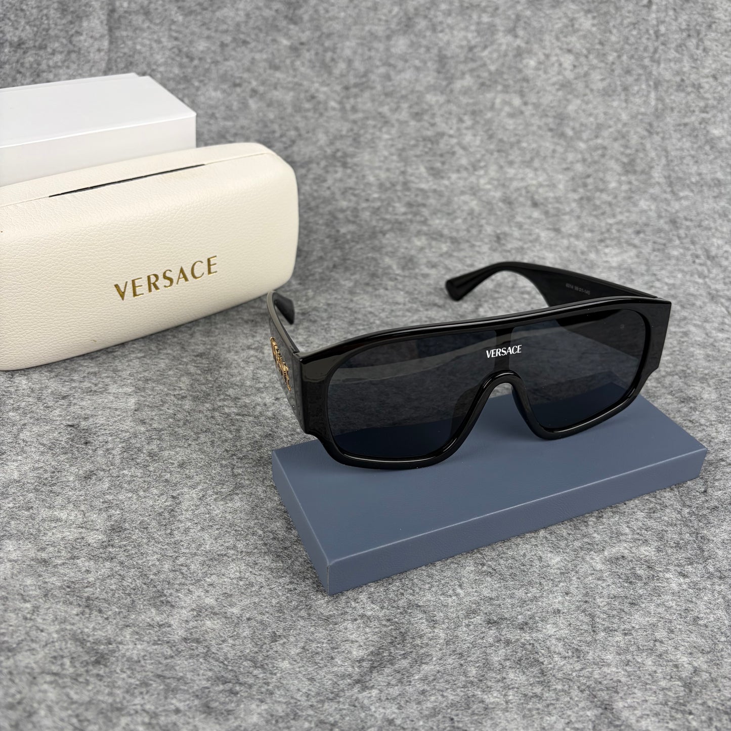Oversized black shield sunglasses with a clean, modern aesthetic and protective hard storage case.