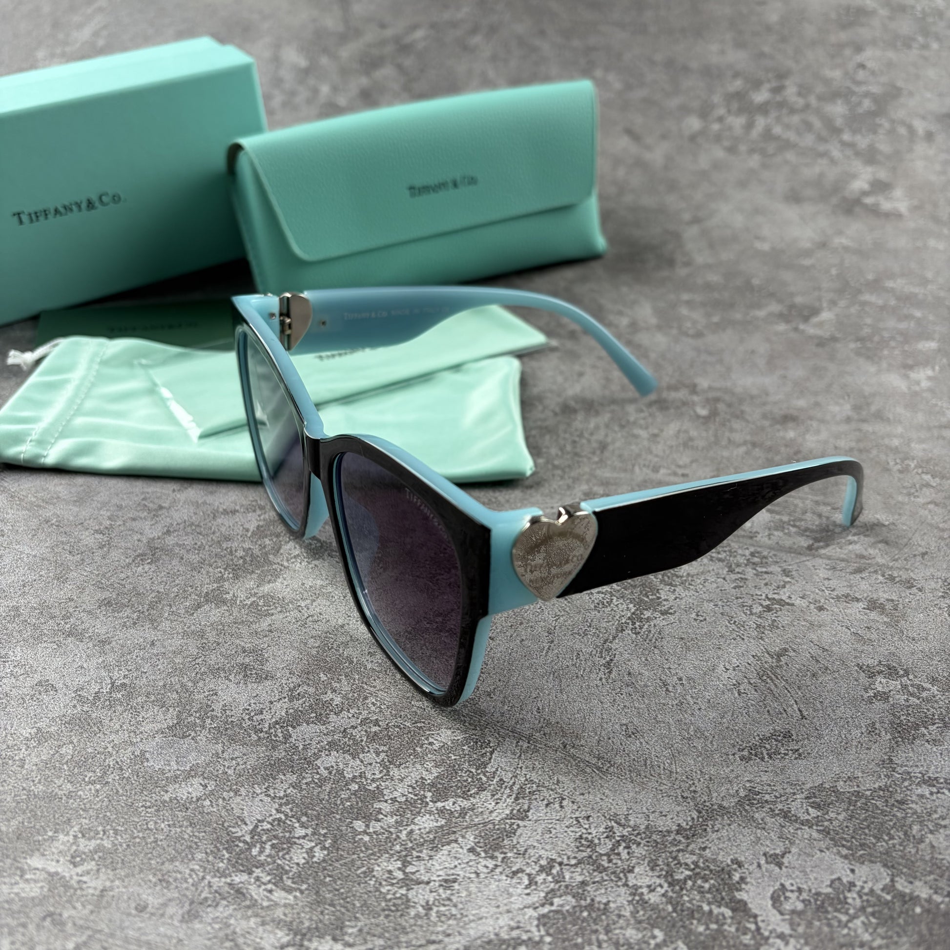 Stylish cat-eye sunglasses with gradient lenses and heart-shaped silver side details.
