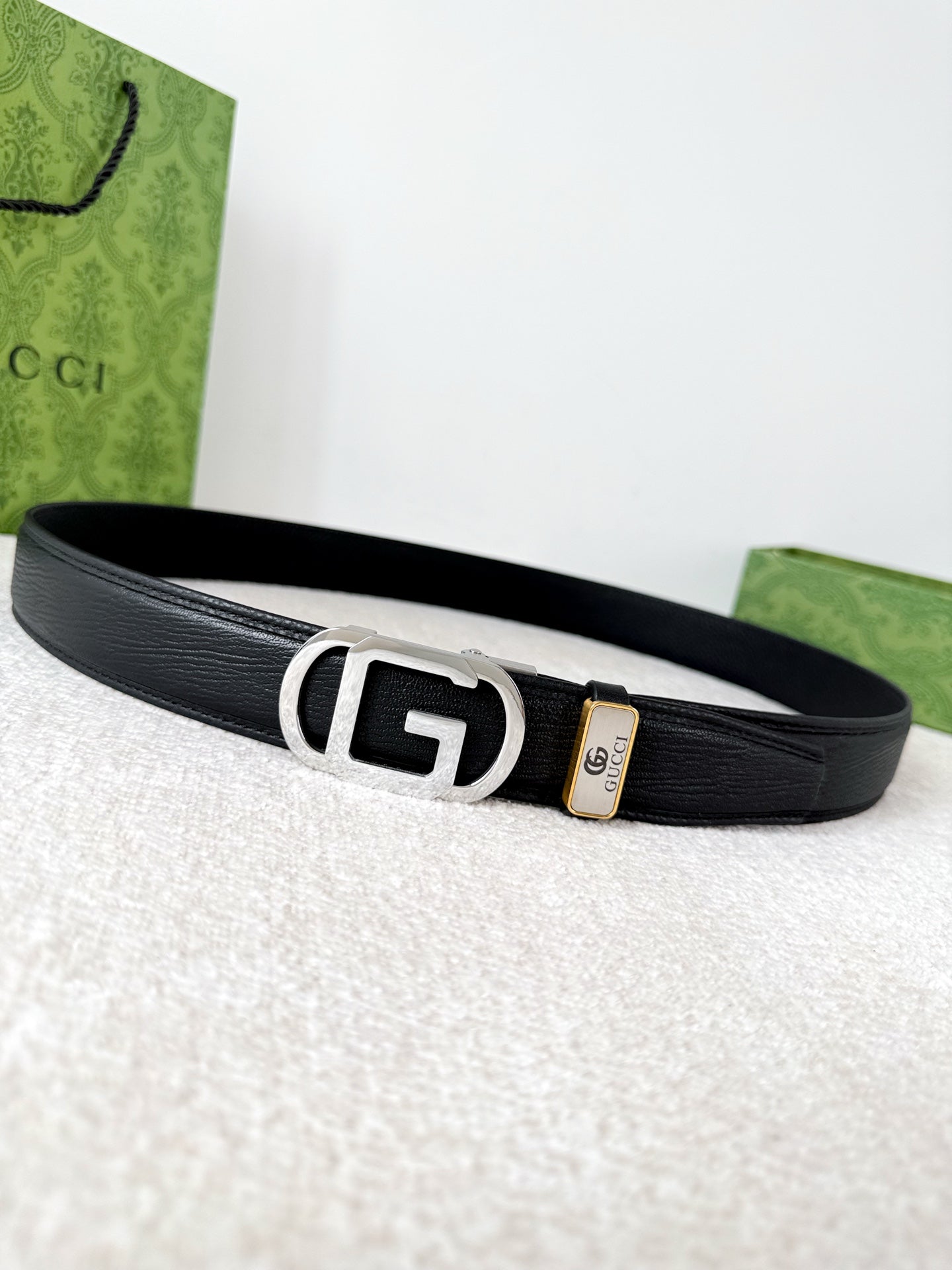Premium black leather belt with a modern silver automatic steel buckle and detailed grain texture.