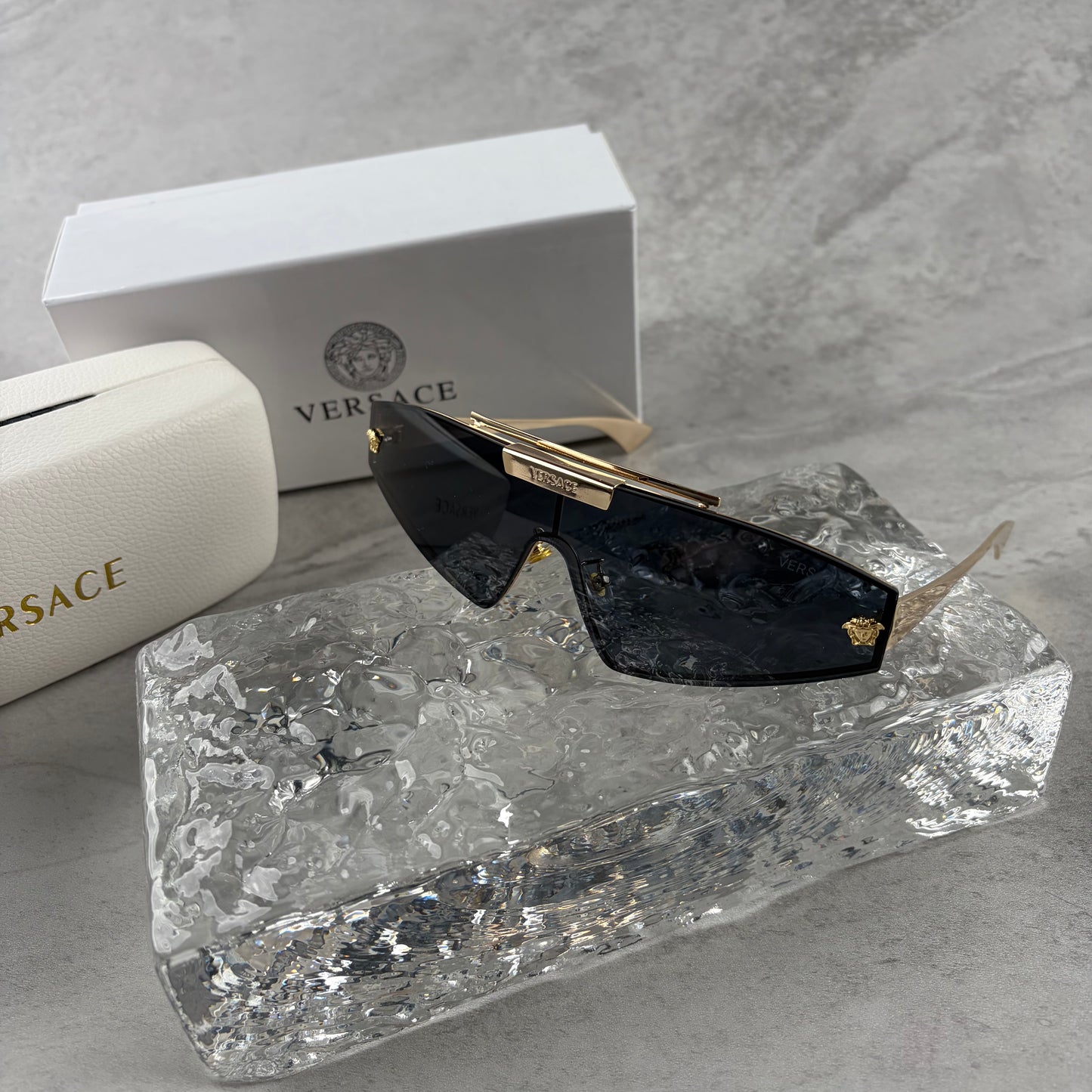 Gold metal frame shield sunglasses with dark lenses, featuring elegant temple detailing.