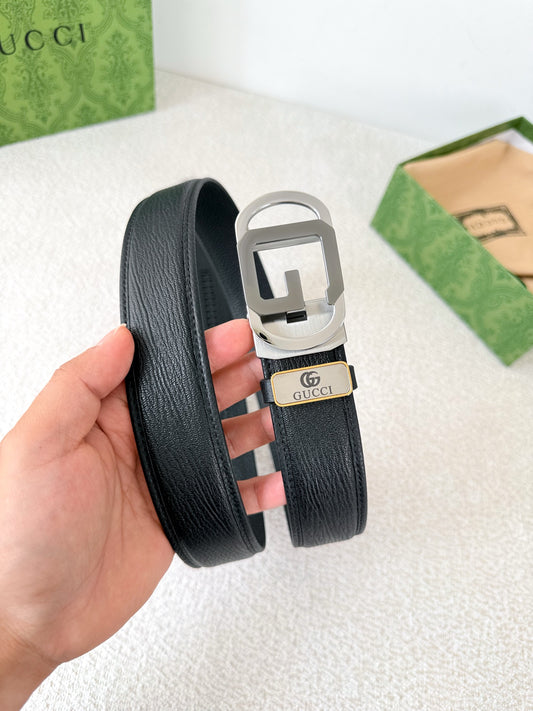 Black textured genuine leather belt with a modern metallic geometric buckle on a white surface.