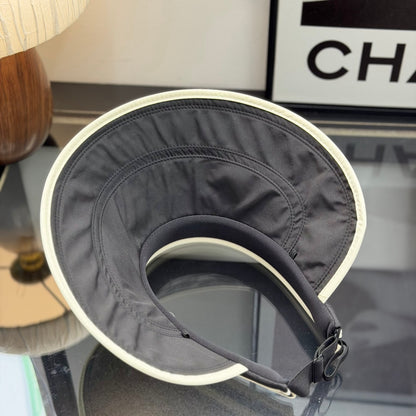 A black sun visor with white contrast trim, featuring an open-top design for breathability and sun p